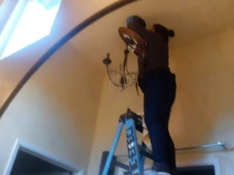 Electrician installing a chandelier in a Ashtabula residence
